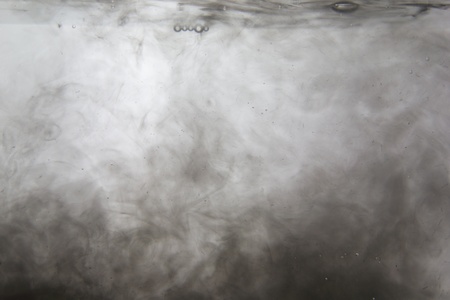 Ink flowing in water creating a black and white abstractの写真素材