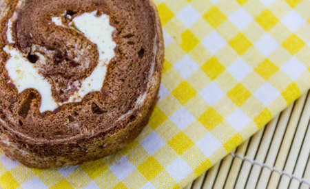 Chocolate roll on yellow tableclothの写真素材