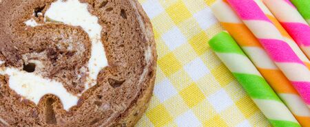 Chocolate roll and Wafer rolls on yellow tableclothの写真素材