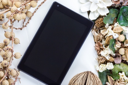 Dry flowers frame on wooden background with tablet computer (tablet pc)の写真素材