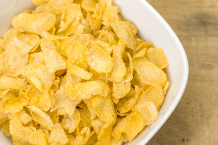 Bowl of corn flakes on wooden background