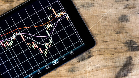 Mobile business concept stock exchange market application on modern black glossy touchscreen smartphone and tablet PC computerの写真素材
