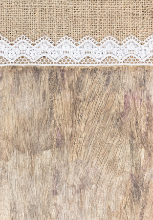 Burlap texture with white lace on wooden table background design for backgroundの写真素材