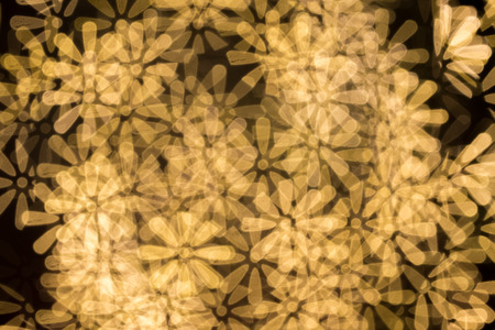 Gold color bokeh flower shape ,defocused bokeh lights as backgroundの写真素材