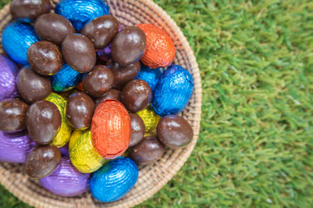 Chocolate Easter Eggs in Basket over grass backgroundの写真素材