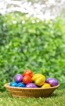 Chocolate Easter Eggs in Basket over Green grass background