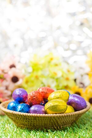 Chocolate Easter Eggs in Basket with flower and bokeh backgroundの写真素材