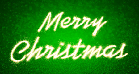 Merry christmas written with Sparkle firework  on green bokeh backgroundの写真素材