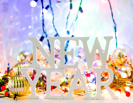 New year white wood character over Defocused bokeh christmas light and christmas balls background