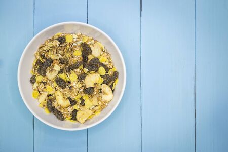 Healthy Granola Whole grains with nuts and dried berries over blue wooden background
