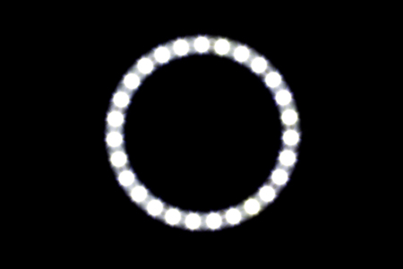 Out of focus circle led light bulb over black backgroundの写真素材