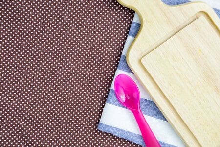 Cutting board with over dots tablecloth and pink spoon on a  tableの写真素材
