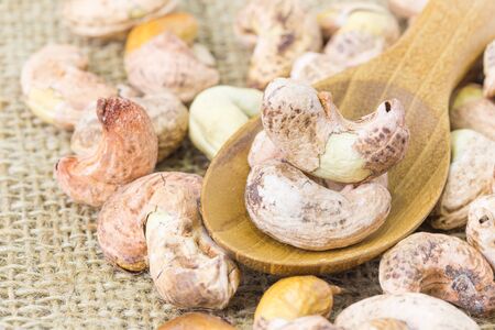cashews close-up in wooden spoon over sackcloth, Selective focusの写真素材