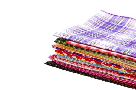 Pile of colorful checkered plaid fabric on a white background
