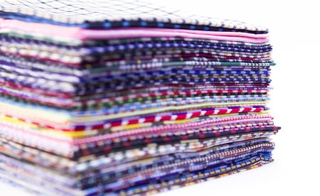 Pile of colorful checkered plaid fabric background