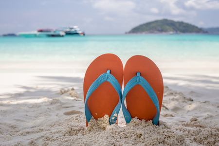Summer vacation concept--Orange flip-flop on the white sand beachの写真素材