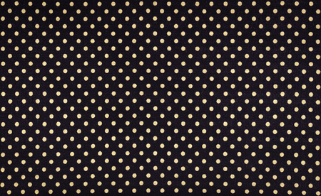 yellow dots over black fabric background and textureの写真素材