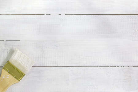 paint brush over white painted wooden surface, wood backgroundの写真素材
