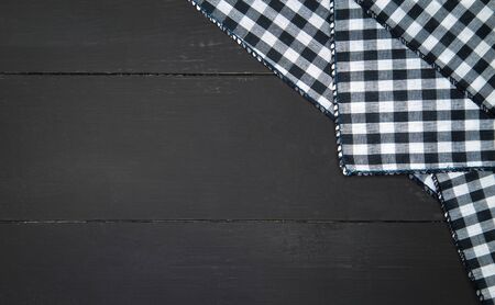 The plaid tartan tablecloth on black wooden table in top viewの写真素材