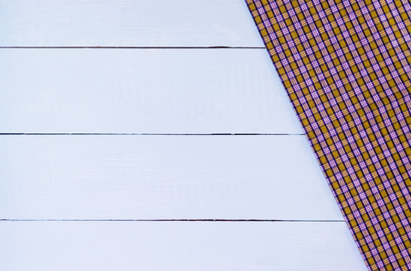 Empty white wooden table covered with checkered tablecloth