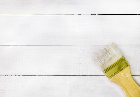 paint brush over white painted wooden surface, wood backgroundの写真素材