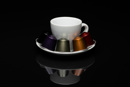 Cup of coffee with capsules on black background with reflectionのeditorial素材