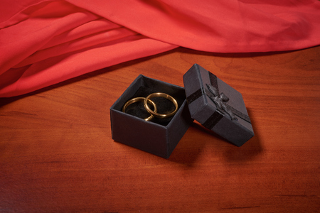 Valentines day gold wedding rings on wooden tableの写真素材