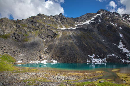 Alpine lake at base of rugged mountainの写真素材