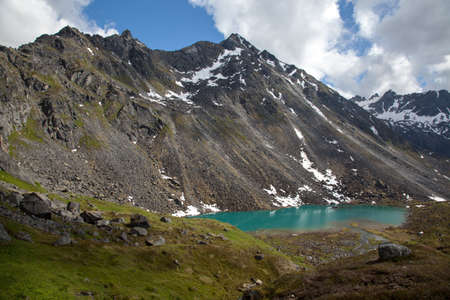 Alpine lake at base of rugged mountainの写真素材