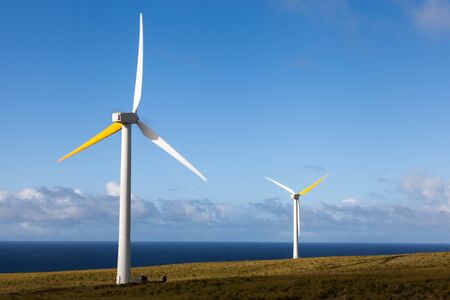 Two wind generators produce renewable energy overlooking Pacific Oceanの写真素材