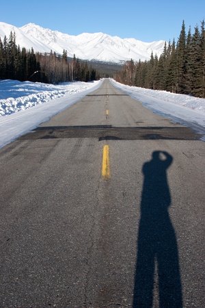 A person stands alone on the Alaska Highway in winter の写真素材