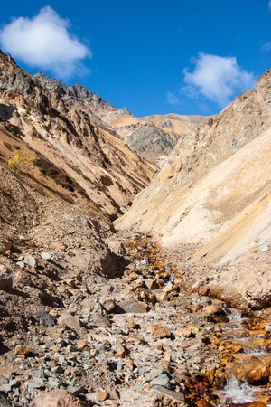 A small creek descends down steep mountain valleyの写真素材