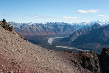 Rugged snow capped peaks rise above autumn lowlandsの写真素材