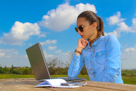 A women with laptop, sitting in the garden,Work from homeの写真素材
