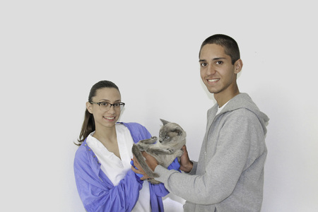 A young man brings a cat to a veterinarianの写真素材