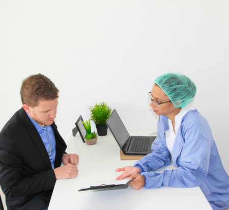 Meeting between a doctor and a patient in at the office with formsの写真素材