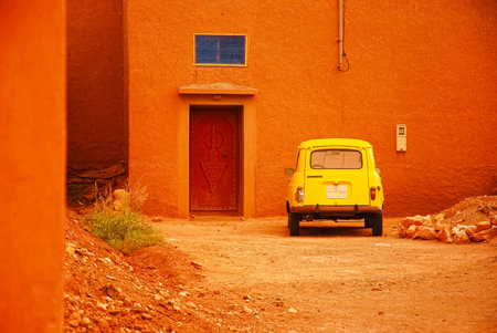 a yellow car parked in front of the red gateの写真素材