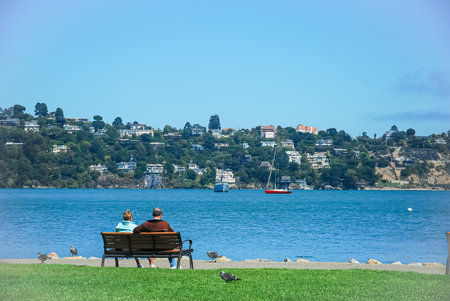 Elderly couple sitting on a bench by the sea in San Franciscoの写真素材