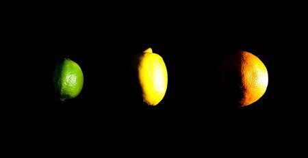 Orange, lemon and lime on black の写真素材