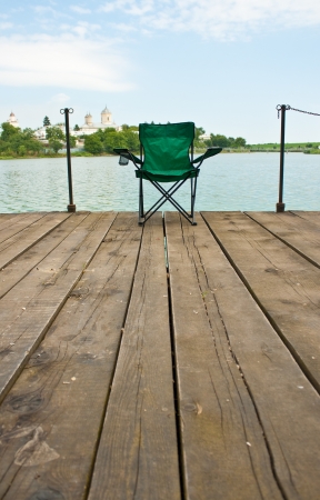 Lonely chair on a wooden pier near the lakeの写真素材