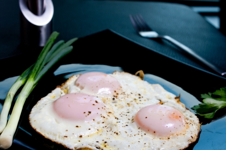 Fried eggs seasoned with salt and pepperの写真素材