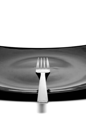 Elegant fork on top of a black rectangular plateの写真素材