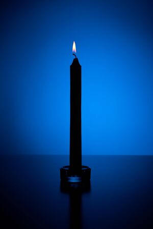 Candle in blue lit backgroundedの写真素材