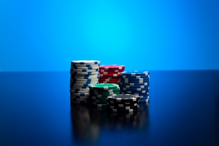 Poker chips with blue lit backgroundの写真素材