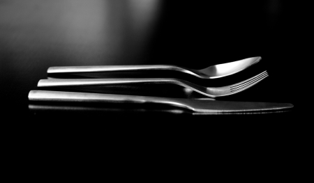 Silverware on black table (shallow DOF, focus on fork)