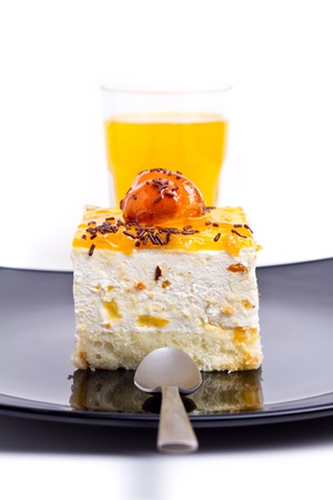 Peach cake on black plate with juice asideの写真素材