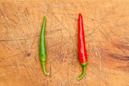 Two chilli peppers on a cutting board