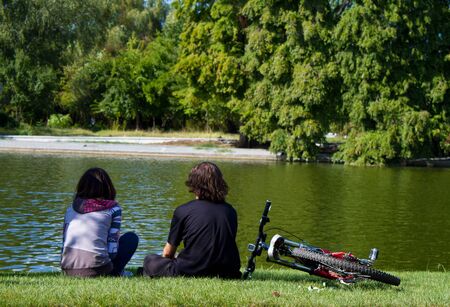 Teens sitting on the grass in the parkの写真素材
