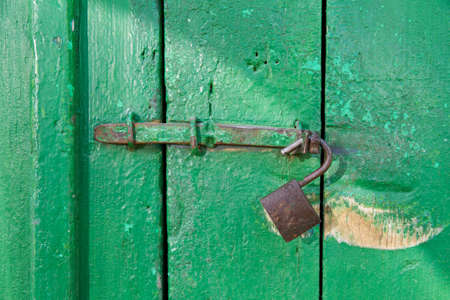 Grungy door with an old unlocked lock