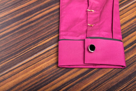 Black and silver cufflinks on a purple shirt